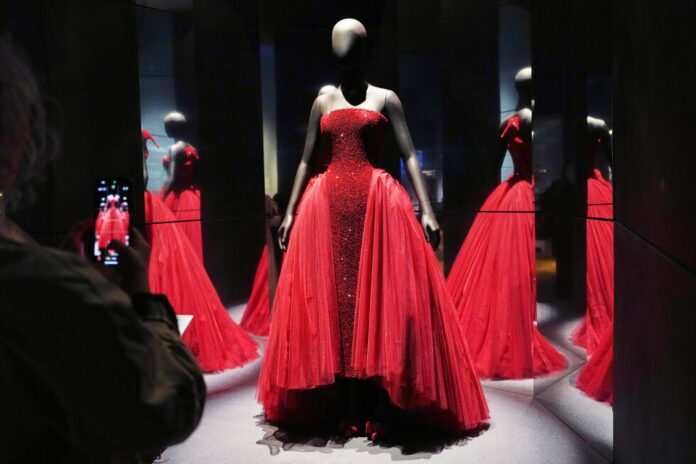 Red strapless ballgown with a beaded bodice on a mannequin in a mirrored display.