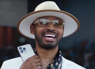 Who Is Stunt Lifestyle? Inside the We In Miami Podcast Host Turning Miami Into Viral Celebrity Media Man in a white suit and hat, smiling, holding a smartphone and a citrus cocktail.